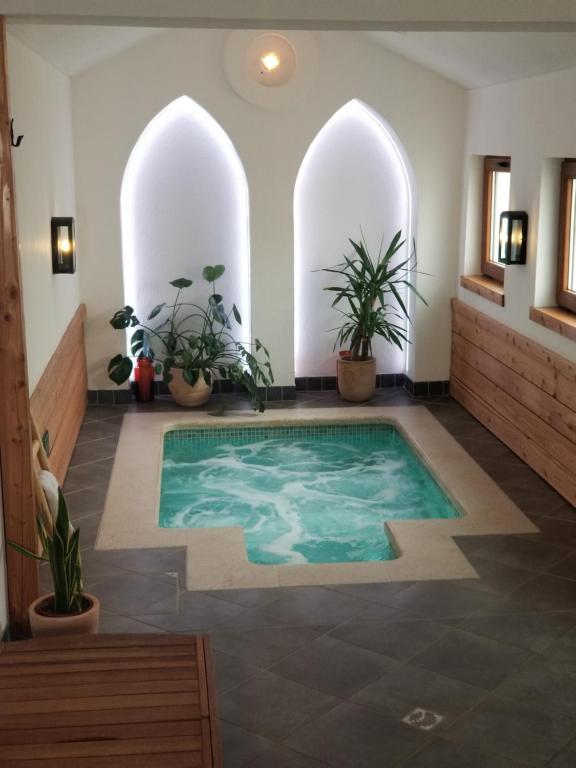 una piscina al centro di una stanza con piante di Wellness B&B Winery Sontacchi a Kutjevo