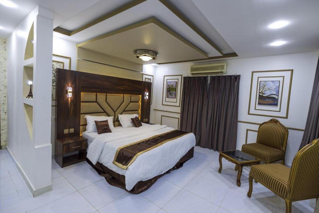 a hotel room with a bed and a chair at Villa Mans 2 in Al-ʿUla