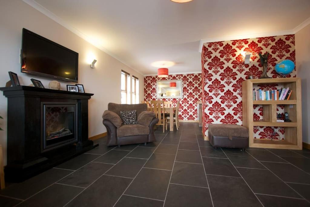 sala de estar con chimenea y TV en Wesdale, Stromness - 3 Bedroom Holiday Cottage en Orkney