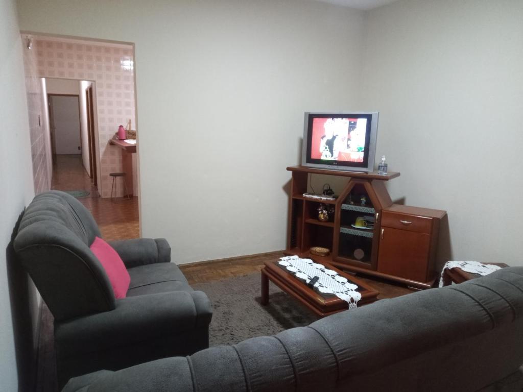 a living room with a couch and a tv at Casinha in Socorro