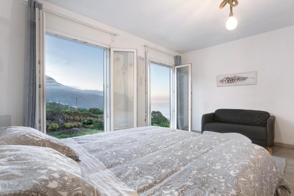 a bedroom with a bed and a large window at Casita Rural La Piñera in Los Realejos