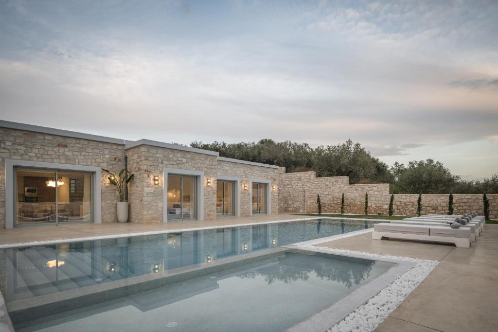 una piscina di fronte a una casa di Ayali Villa II, a divine luxury homestay, By ThinkVilla ad Akhladhés