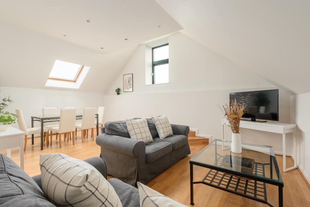 a living room with a couch and a table at The Modern Mill Apartment in Edinburgh