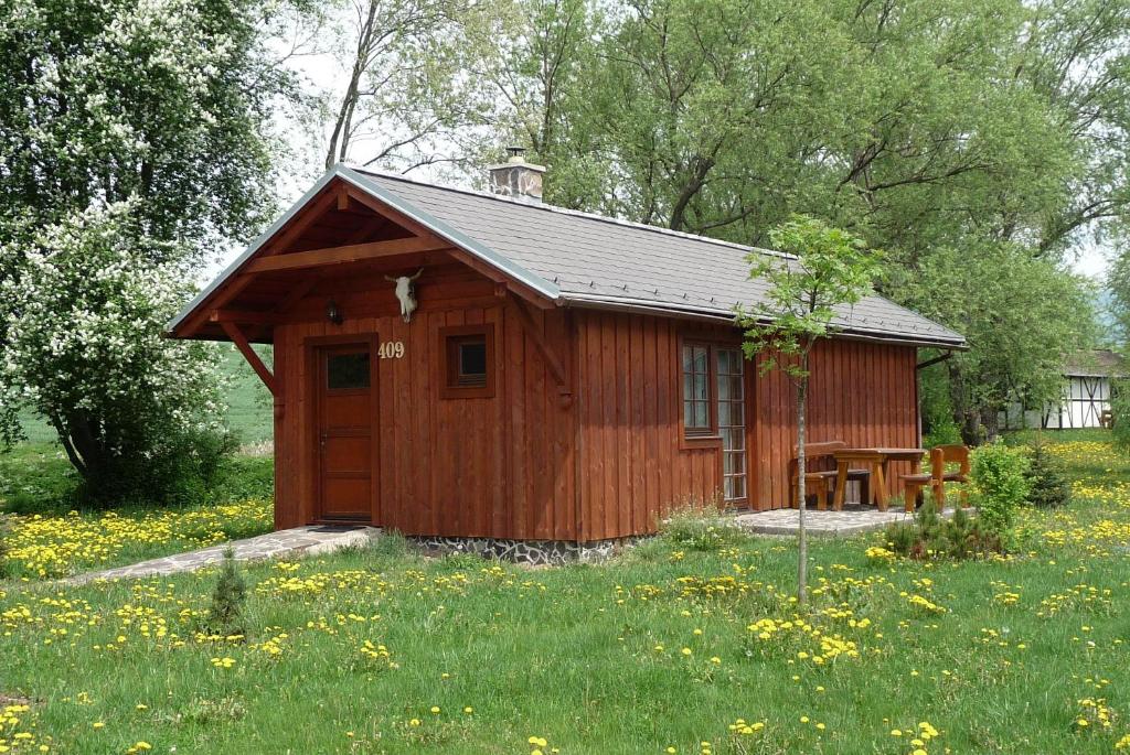 mały drewniany domek na polu trawy w obiekcie Holiday home at Aquapark Tatralandia w Liptowskim Mikulaszu
