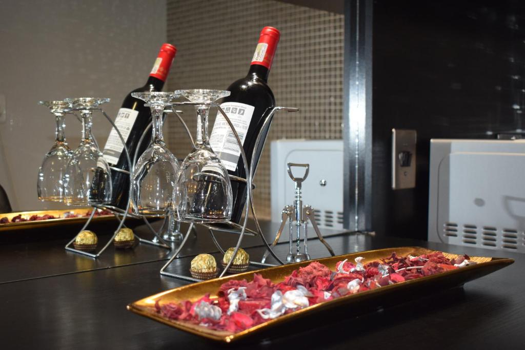 a table with two bottles of wine and a pizza at Scenery Maqalika Guesthouse in Maseru