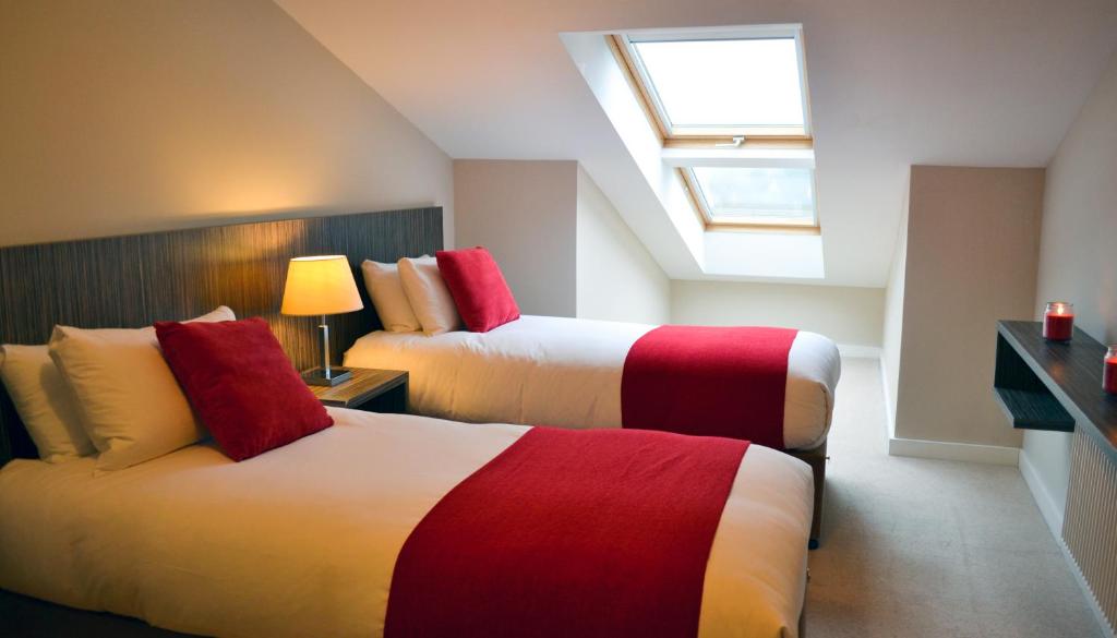 a hotel room with two beds and a skylight at Carrick Plaza Suites and Apartments in Carrick on Shannon