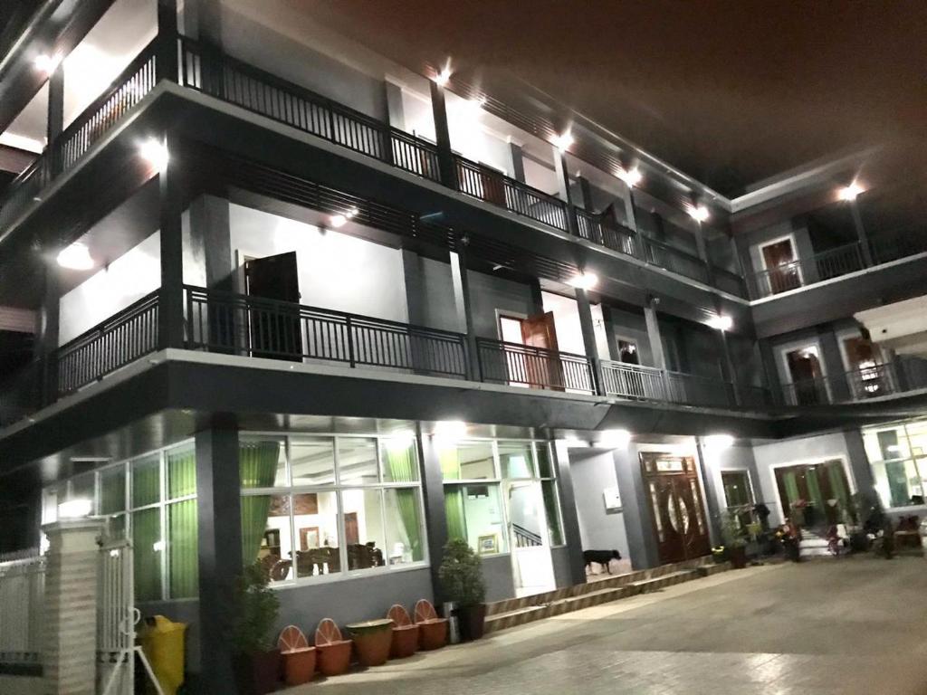 um edifício de apartamentos à noite com luzes em xaythone guest house em Savannakhet
