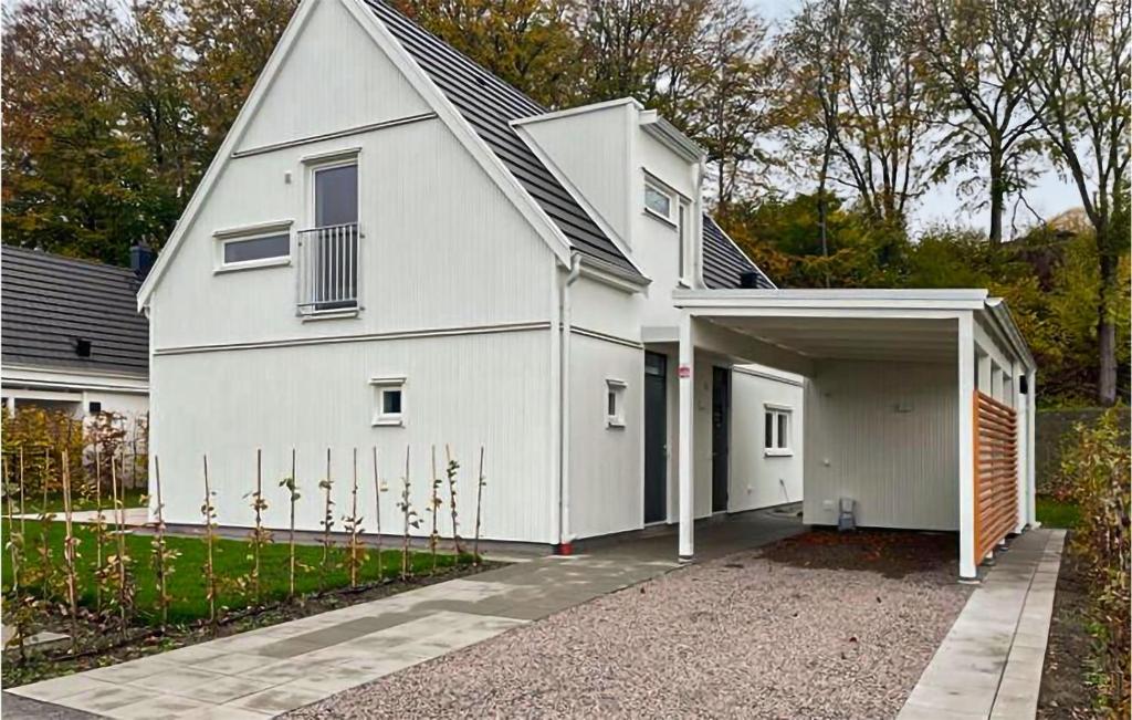 een wit huis met een garage en een oprit bij Stunning Home In Bstad With Wifi in Båstad