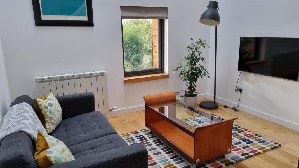 a living room with a couch and a coffee table at The Studio Room at Wester Den in Arbroath