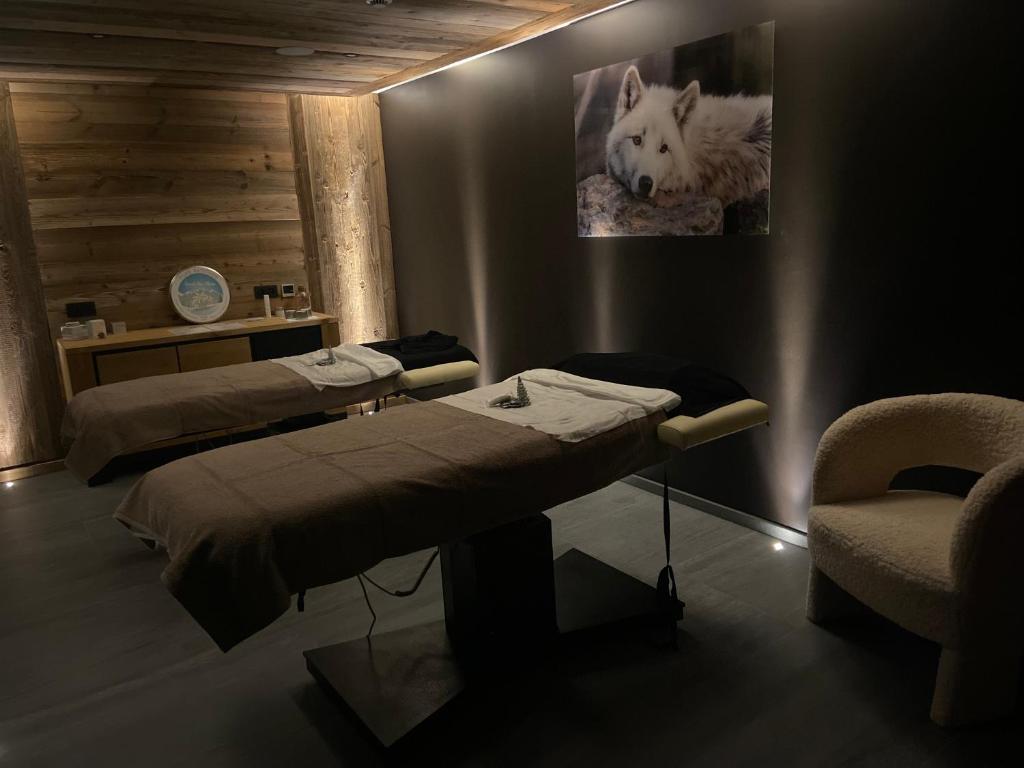 a hospital room with two beds and a chair at Hôtel Alpina &amp; SPA in Les Gets