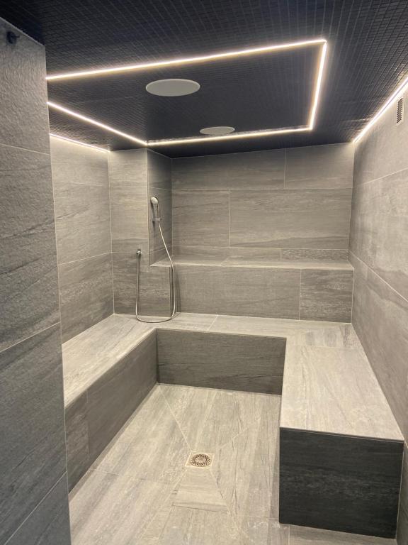 a bathroom with a tub with a shower at Hôtel Alpina &amp; SPA in Les Gets