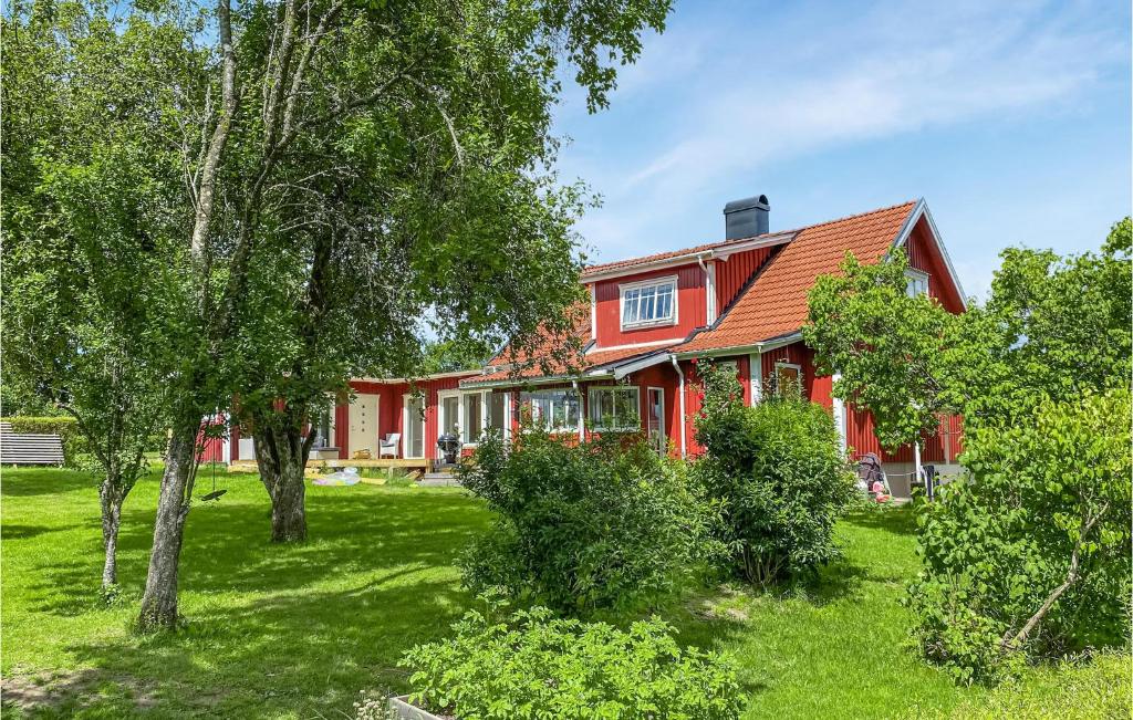 una casa roja con árboles delante de ella en 2 Bedroom Amazing Home In Havstenshult 