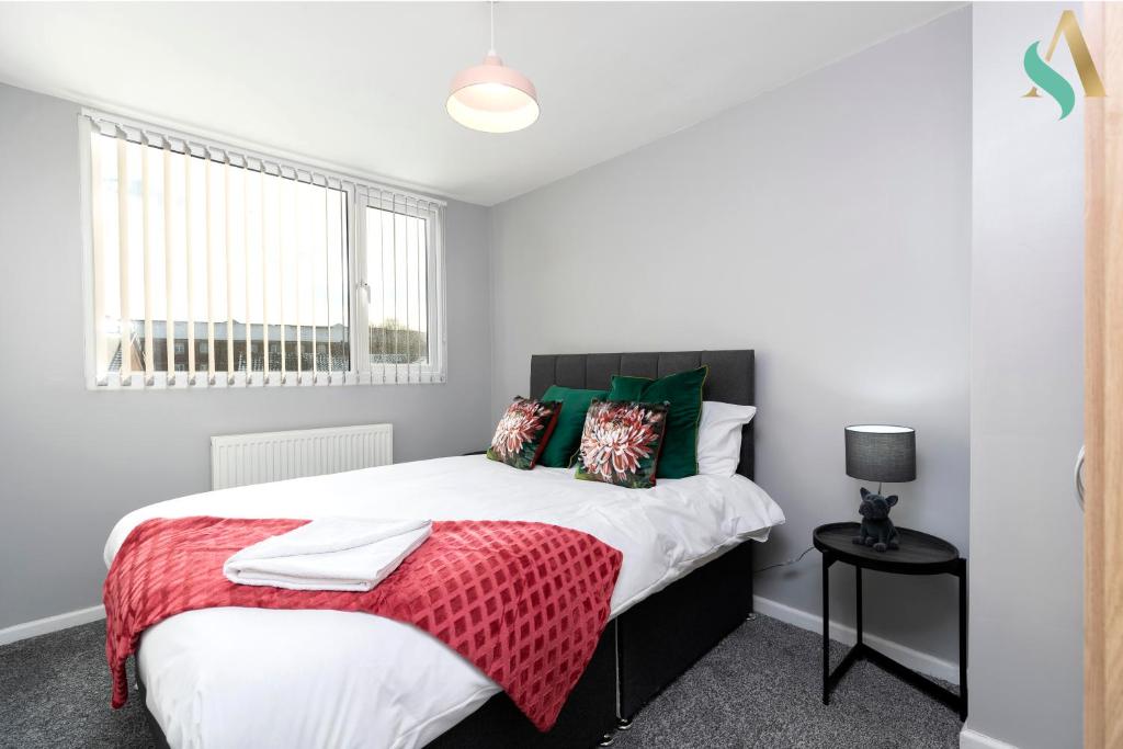 ein Schlafzimmer mit einem Bett mit einer roten Decke in der Unterkunft Wroxton Close TSAC in Middlesbrough
