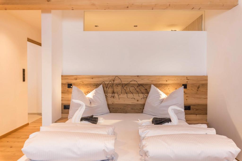 two beds in a room with white pillows at Planerhof Apartment Edelweiss in Funes