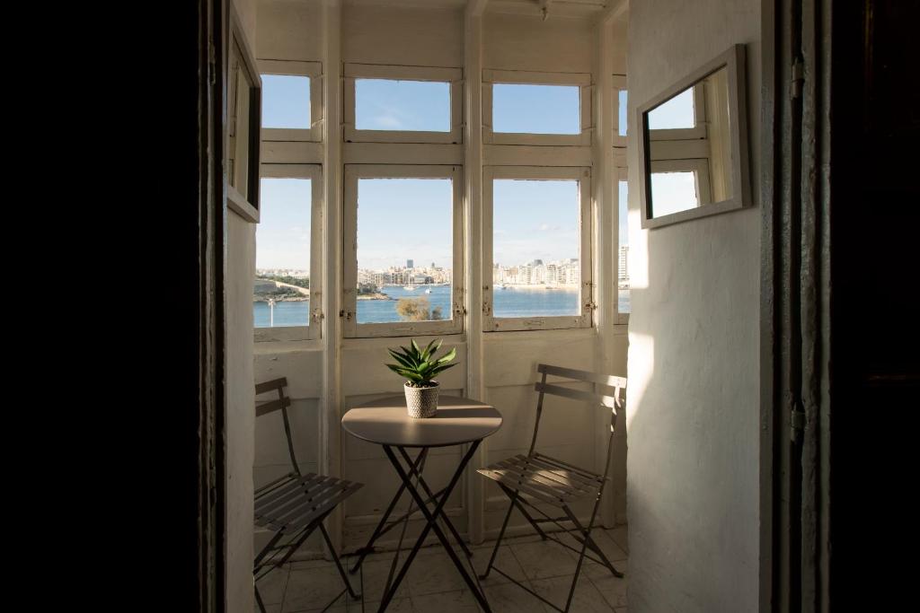 uma mesa e duas cadeiras num quarto com uma janela em Valletta Collection - Old Theatre em Valeta