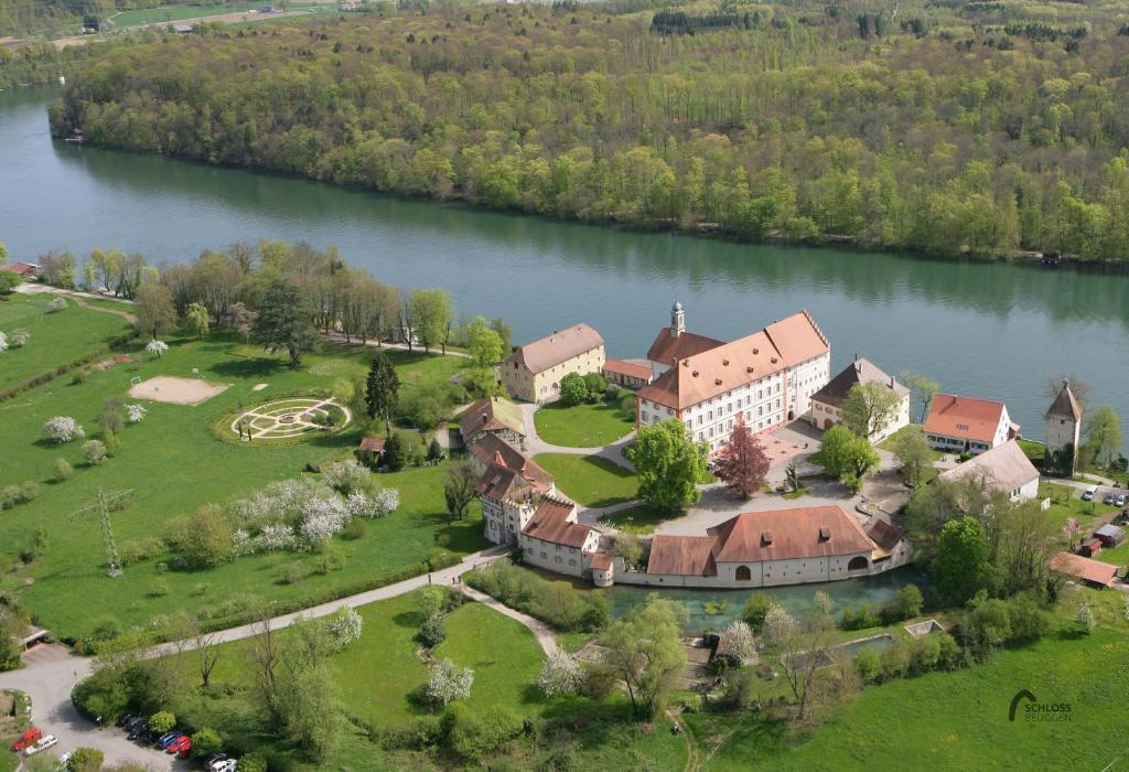 eine Luftansicht eines großen Hauses auf einem See in der Unterkunft Schloss Beuggen in Rheinfelden