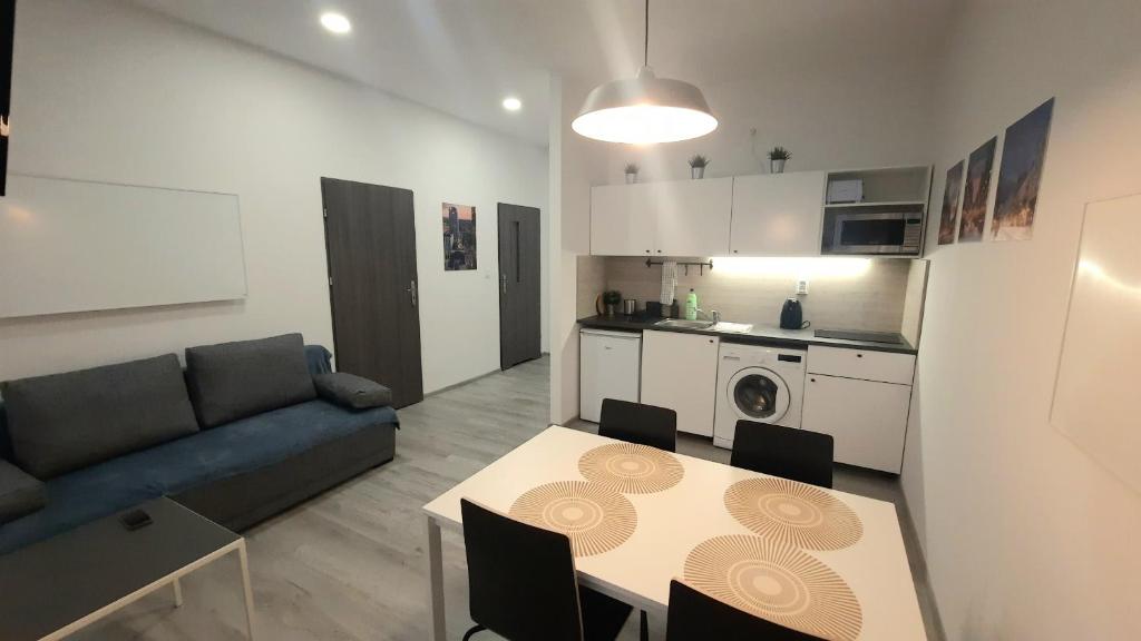 een woonkamer met een bank en een tafel en een keuken bij DeLux12 in Łódź