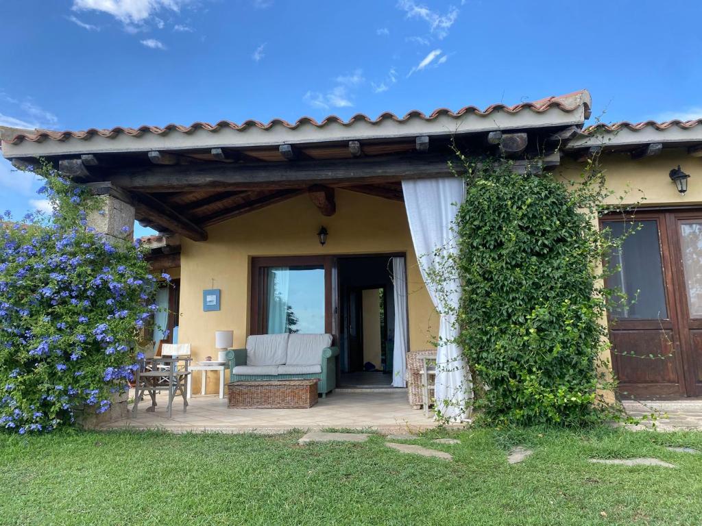 Casa con porche con sofá y patio en La casa di Camilla a Punta Molara, en Monte Petrosu