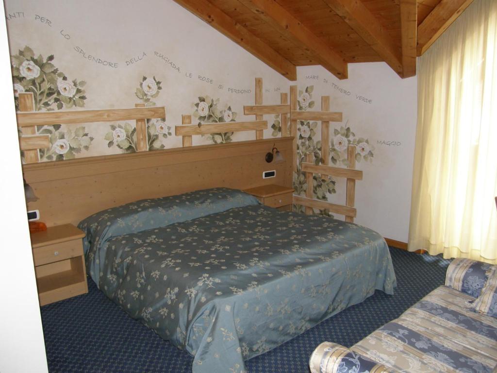 - une chambre avec un lit et des étagères sur le mur dans l'établissement Villa Ilaria, à Caderzone Terme