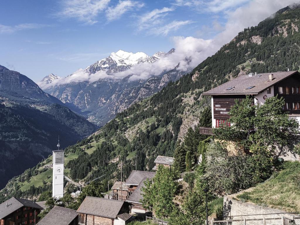 a village in the mountains with a snow covered mountain at Berghotel Weisshorn in Törbel