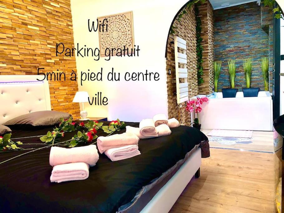 a room with a bed with towels on it at La suite romantique Jacuzzi,parking gratuit,centre in Sens