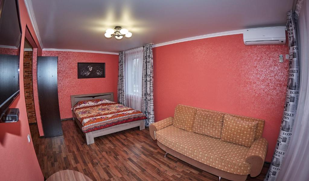 sala de estar con sofá y cama en Триумф, en Petropavlovsk