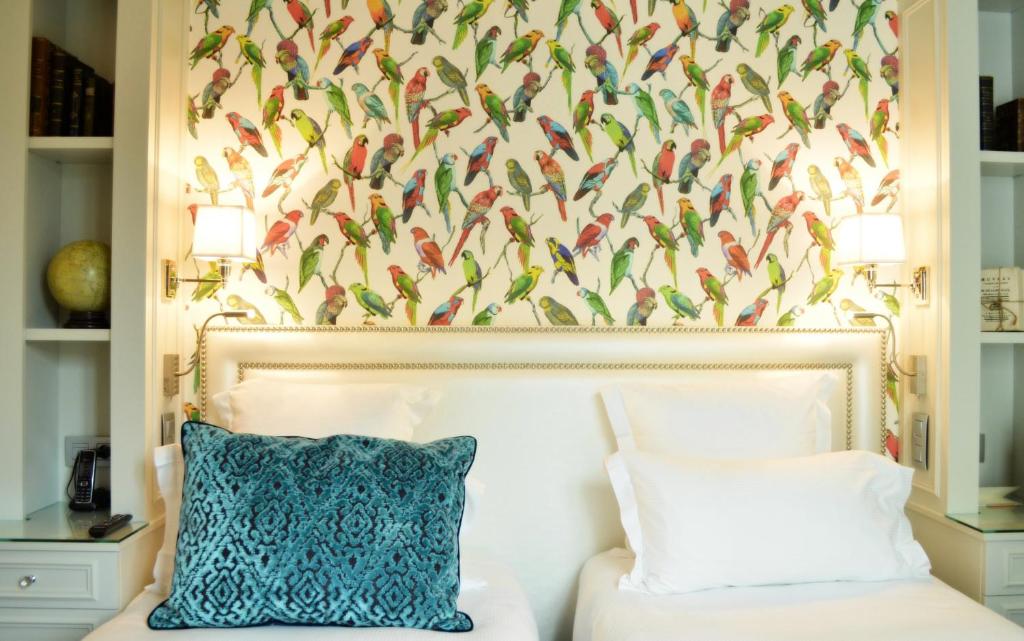 a bedroom with a bed with a bird wallpaper at Hotel Monge in Paris