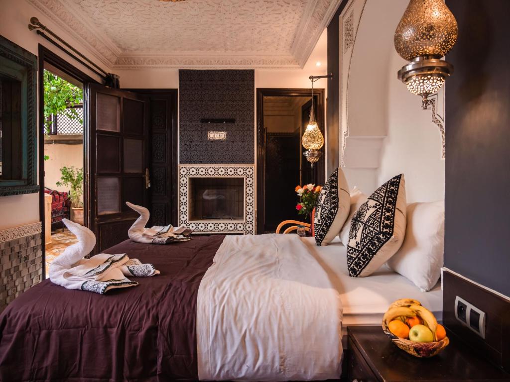 ein Schlafzimmer mit einem großen Bett mit zwei Schwänen darauf in der Unterkunft Riad Zagouda in Marrakesch