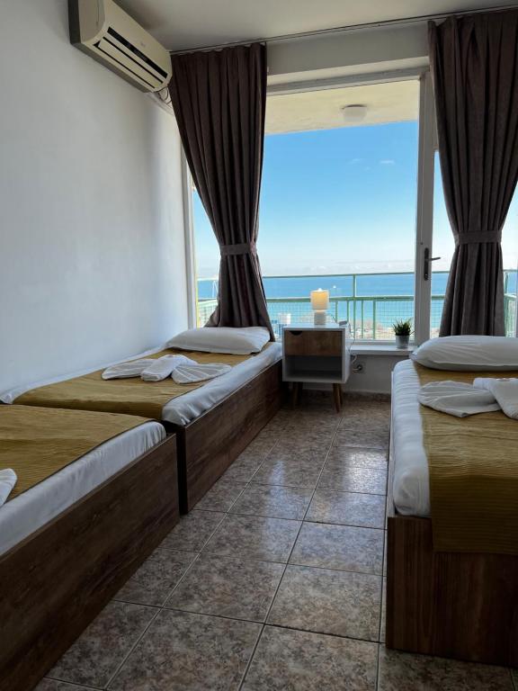a bedroom with two beds and a view of the ocean at Hotel Varshava in Golden Sands