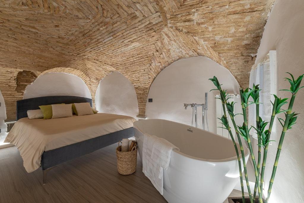 a bedroom with a bed and a bath tub at L'ira di Dante in Gubbio