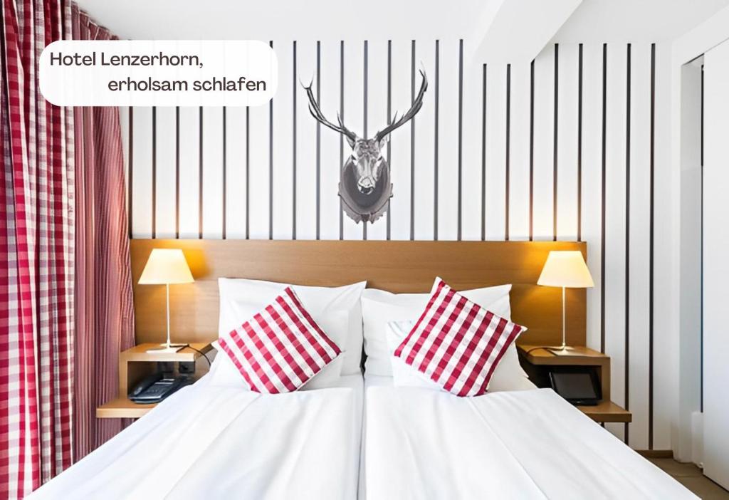 a bedroom with a bed with two red and white pillows at Hotel Lenzerhorn in Lenzerheide