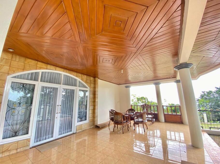 sala de estar con techo de madera y mesa en Villa Nada Situgunung. 