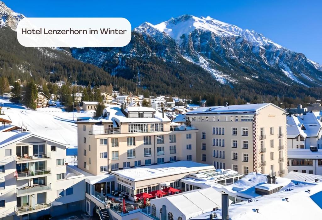 eine Stadt mit schneebedeckten Bergen im Hintergrund in der Unterkunft Hotel Lenzerhorn in Lenzerheide