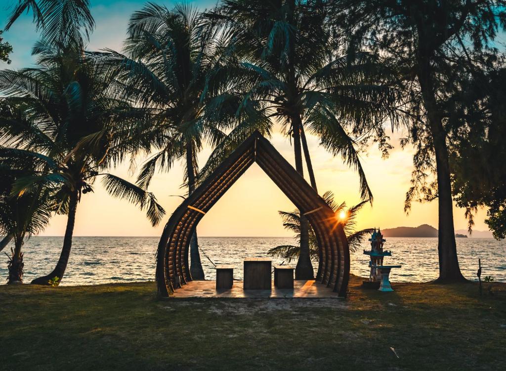 ein Zelt am Strand mit Palmen bei Sonnenuntergang in der Unterkunft Lazy Day The Resort in Ko Mak