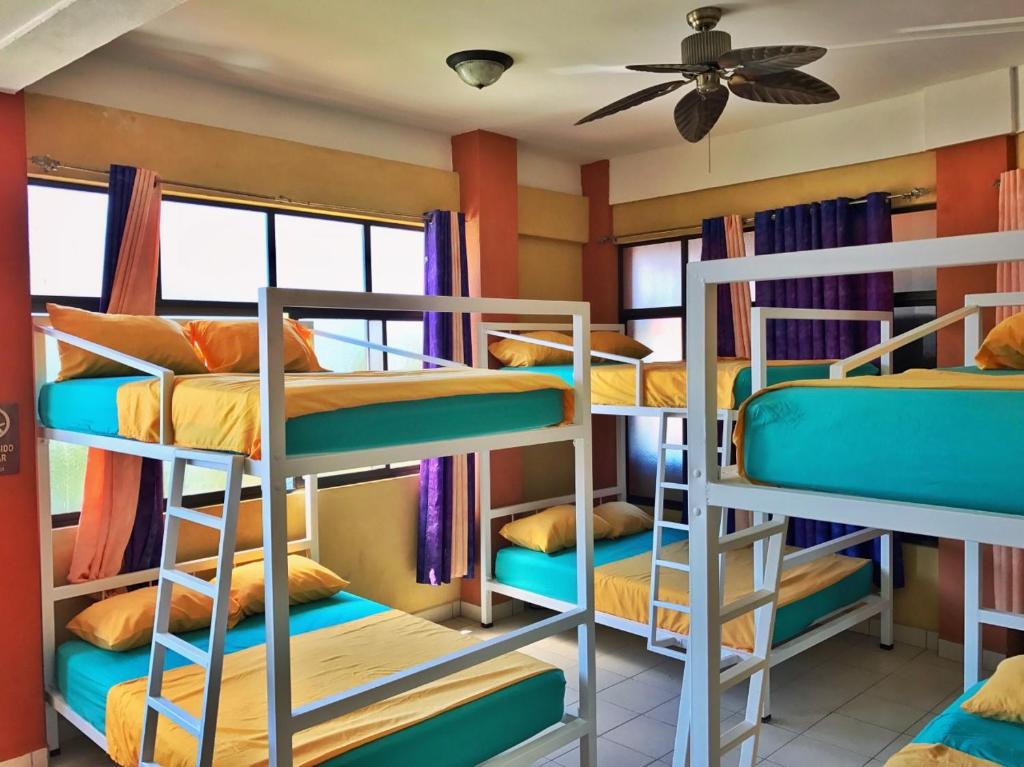 a room with a bunch of bunk beds at Sandy Toes Hostel in Sámara