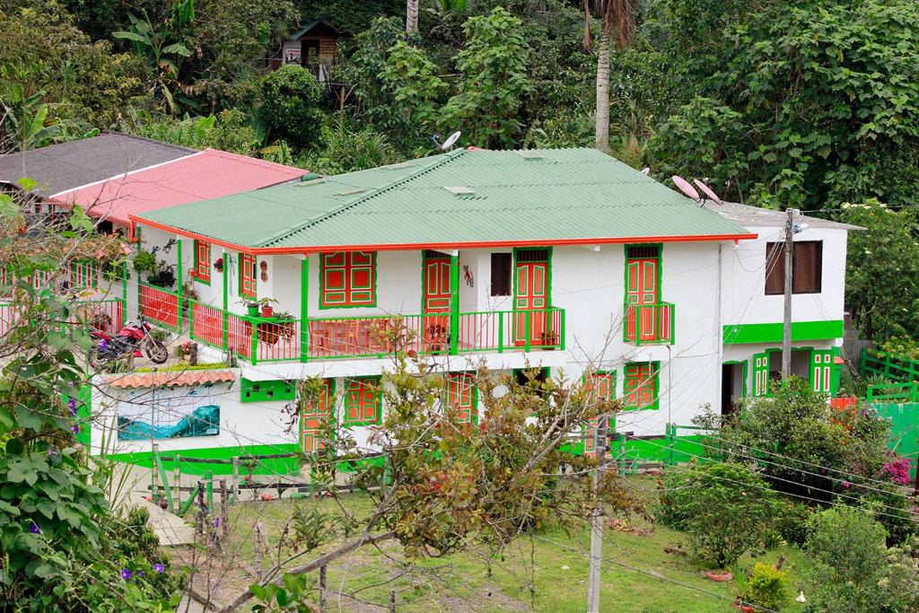 a house with red and green windows in a forest at Hotel Casa Quinta Salento in Salento