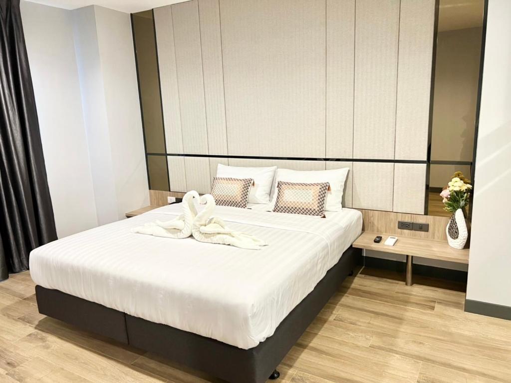 a bedroom with a bed with a bow on it at S.R.SUNSHINE HOTEL in Ban Sok Dua
