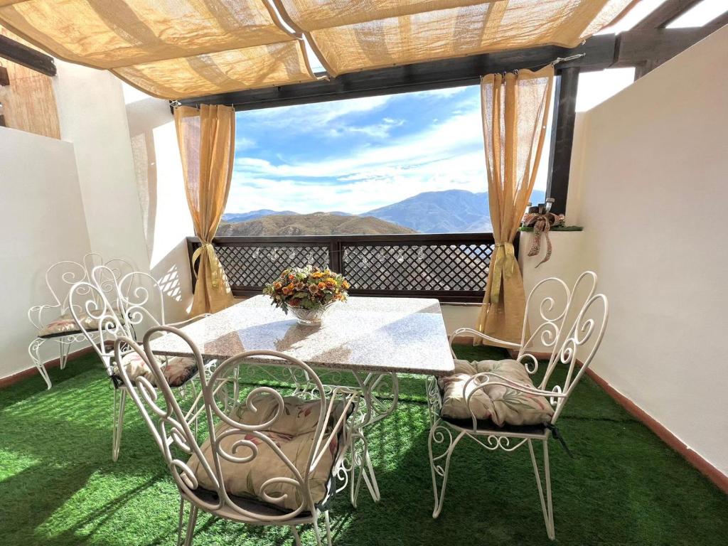 a table and chairs on a balcony with a view at tuGuest Carataunas Apartment Alpujarra V in Carataunas