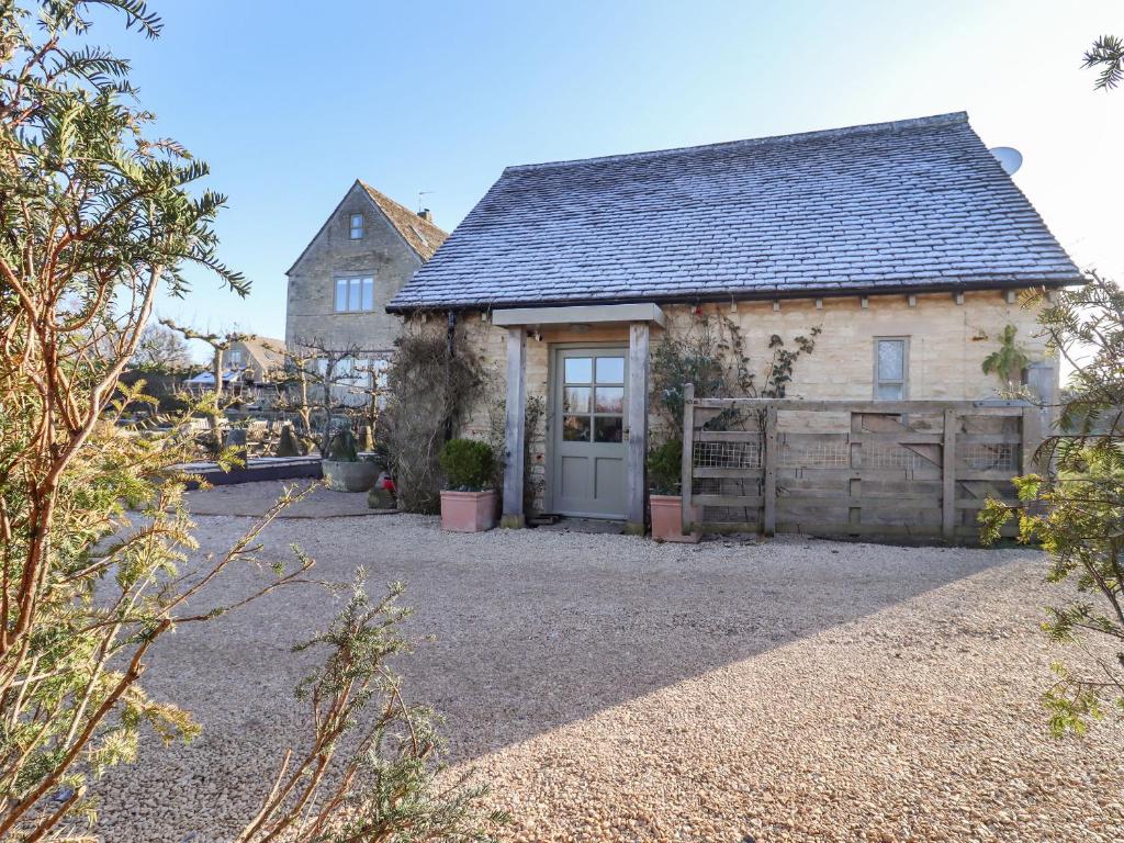 a small house with a door and a barn at Pudding Hill Barn Cottage in Cirencester