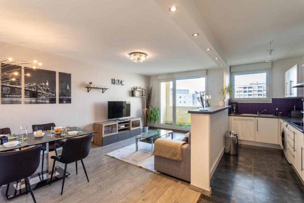 cocina y sala de estar con mesa y sofá en Le Lounge - 2 chambres avec parking en Rennes