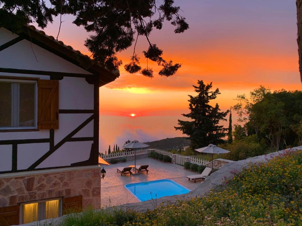 a house with a pool and a sunset in the background at Vissala Village in Chort&aacute;ta