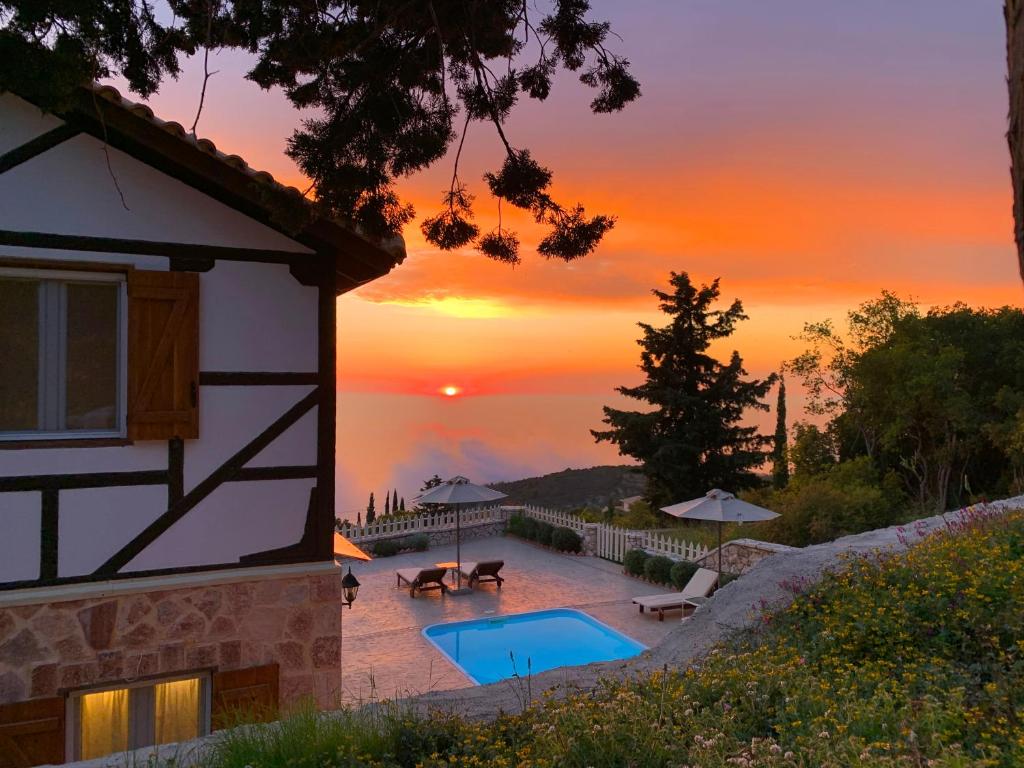 une maison avec une piscine et un coucher de soleil en arrière-plan dans l'établissement Vissala Village, à Chortáta