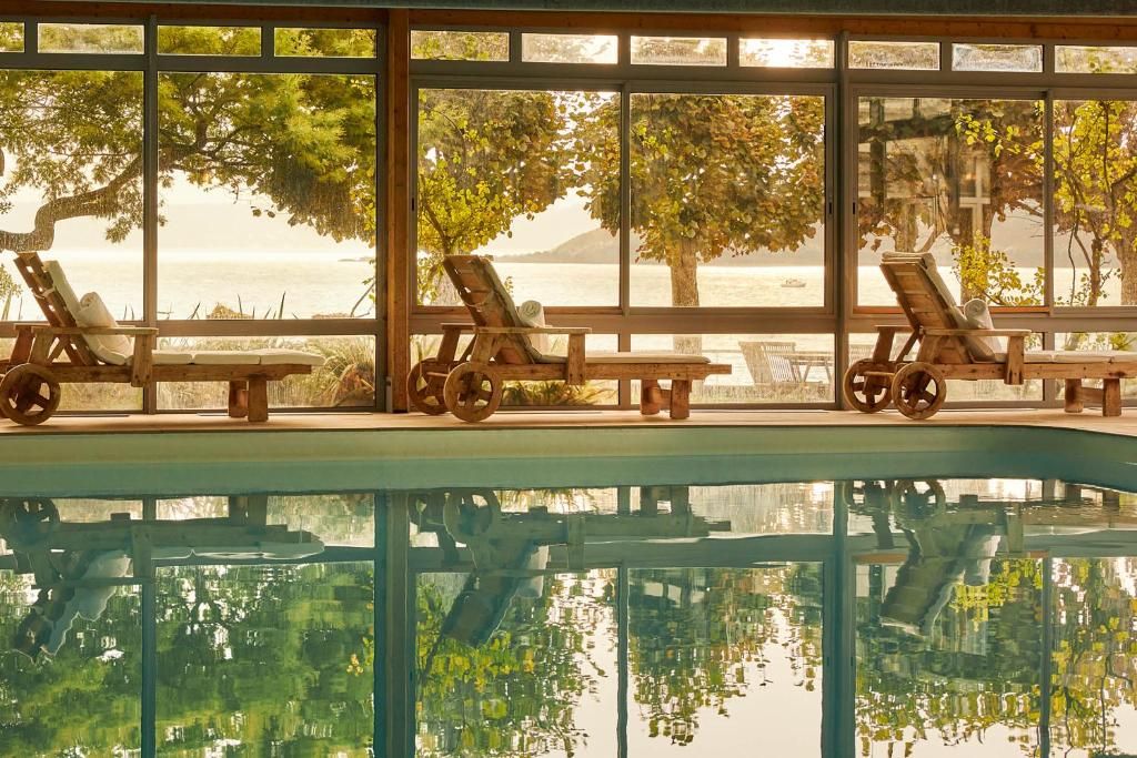 - une piscine avec 2 chaises, une table et un peu d'eau dans l'établissement Le Grand Hotel des Bains & Spa - Bretagne, à Locquirec