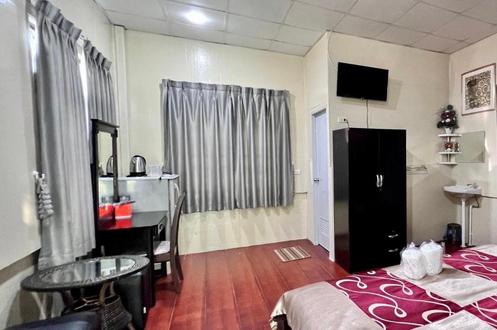 Cette chambre comprend un lit, un bureau et une table. dans l'établissement MrT Riverside Sampran มิสเตอร์ที โฮมสเตย์-การเวก, à Sam Phran