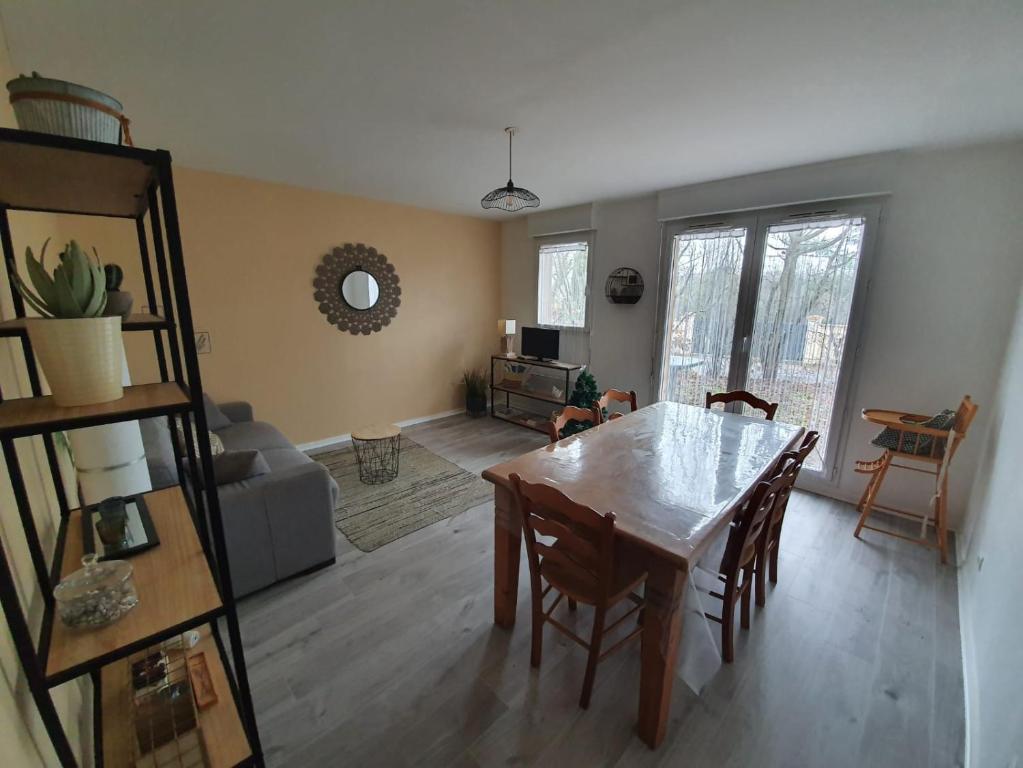 a living room with a table and chairs and a couch at De la détente dans ce coin de campagne. in Équemauville