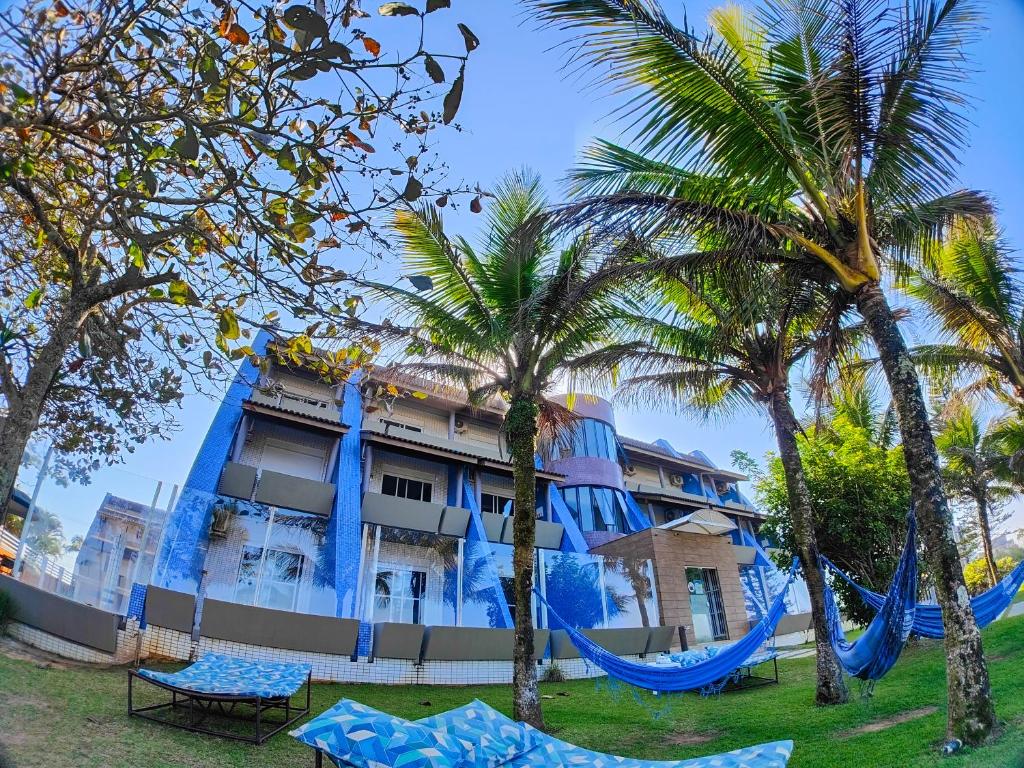 hotel z palmami i hamakami przed nim w obiekcie Spazio Marine Hotel - Guaratuba w mieście Guaratuba