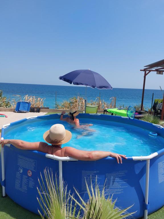 a man in a hat sitting in a swimming pool at Casa en el MAR in Benicarló