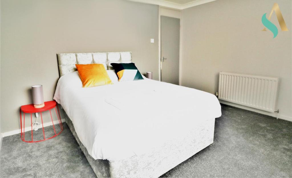 a bedroom with a large white bed and a red table at Newbury Lodge TSAC in Billingham