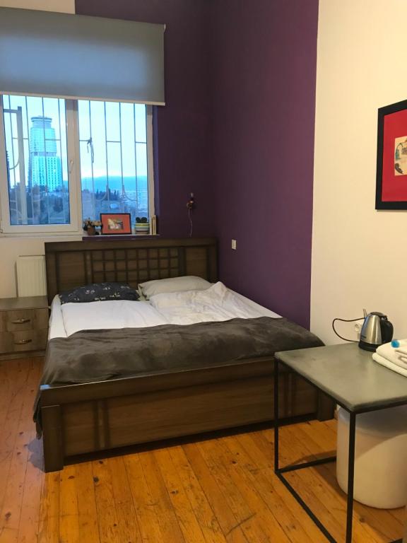 ein großes Bett in einem Zimmer mit Fenster in der Unterkunft BroBro hostel in Tbilisi City