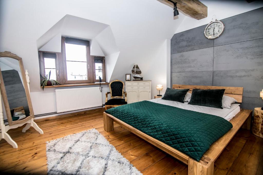 a bedroom with a large bed with a green blanket at AP Apartment's in Wałbrzych
